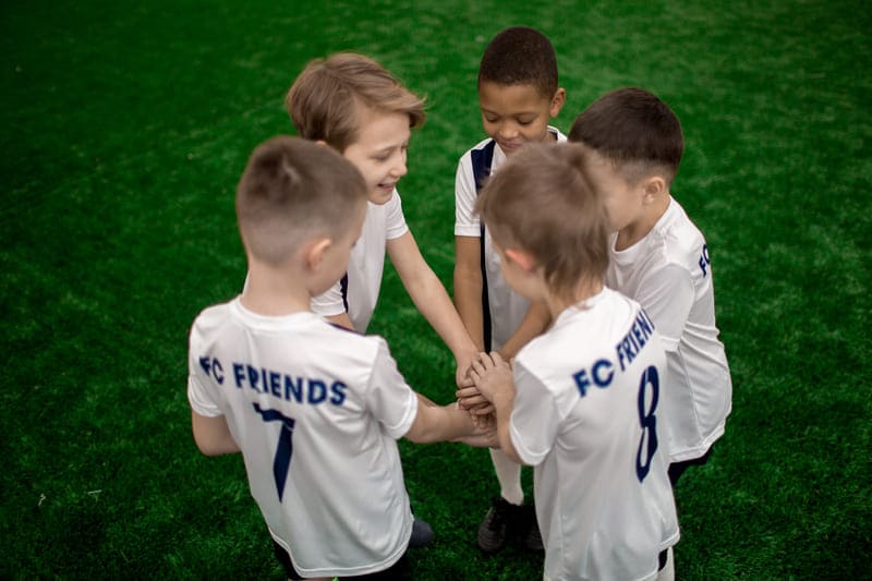 Crianças em roda de conversa durante jogo de futebol
